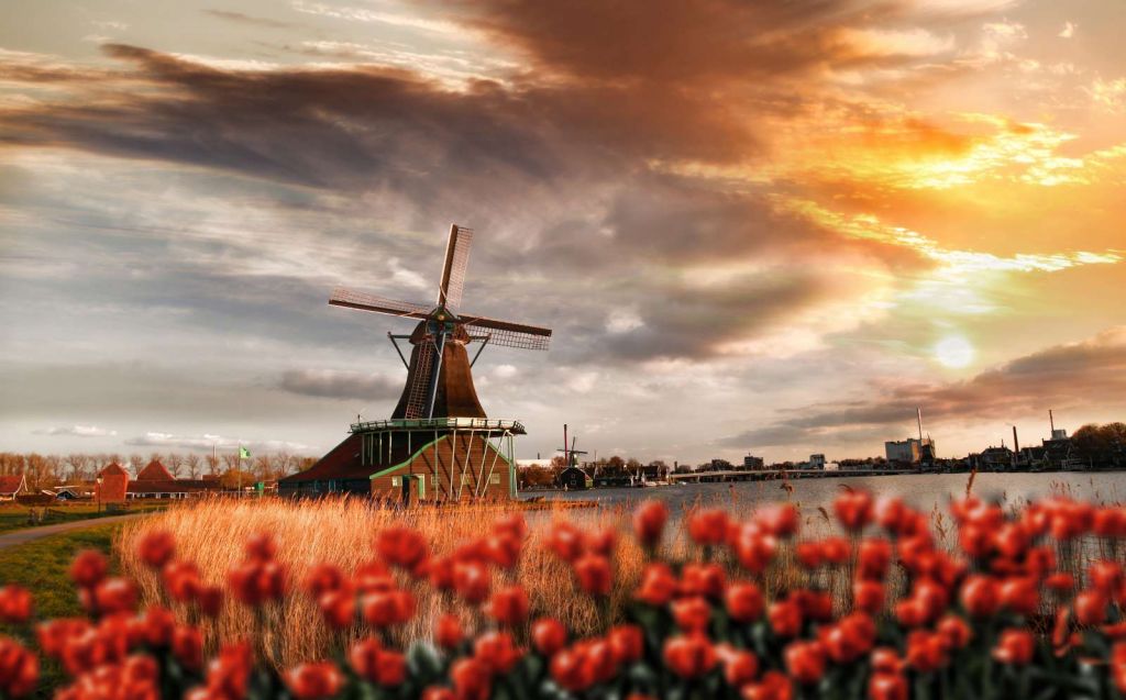 Hollands landschap met molen bij zonsondergang