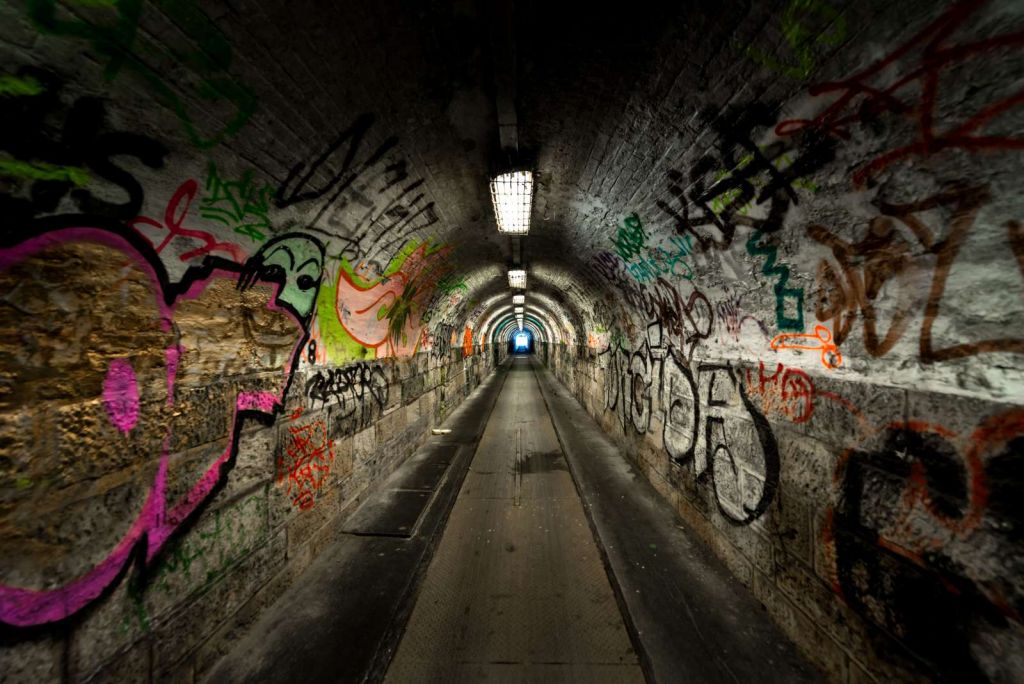 Lange ondergrondse tunnel met graffiti op de muren