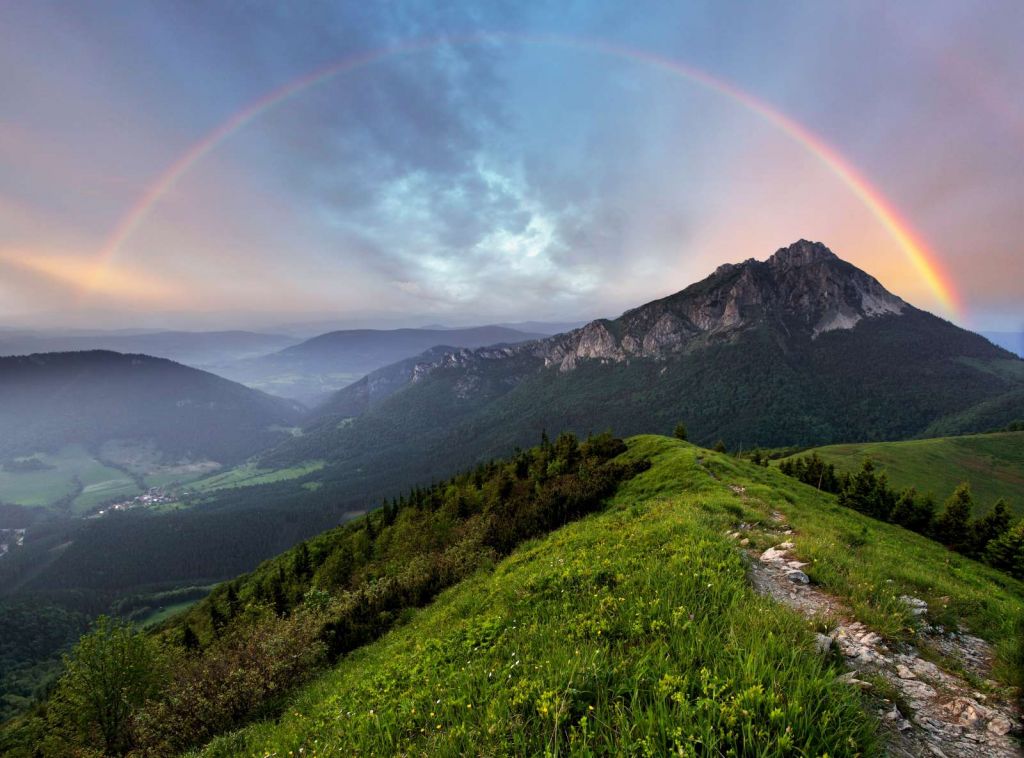 Regenboog boven een berglandschap